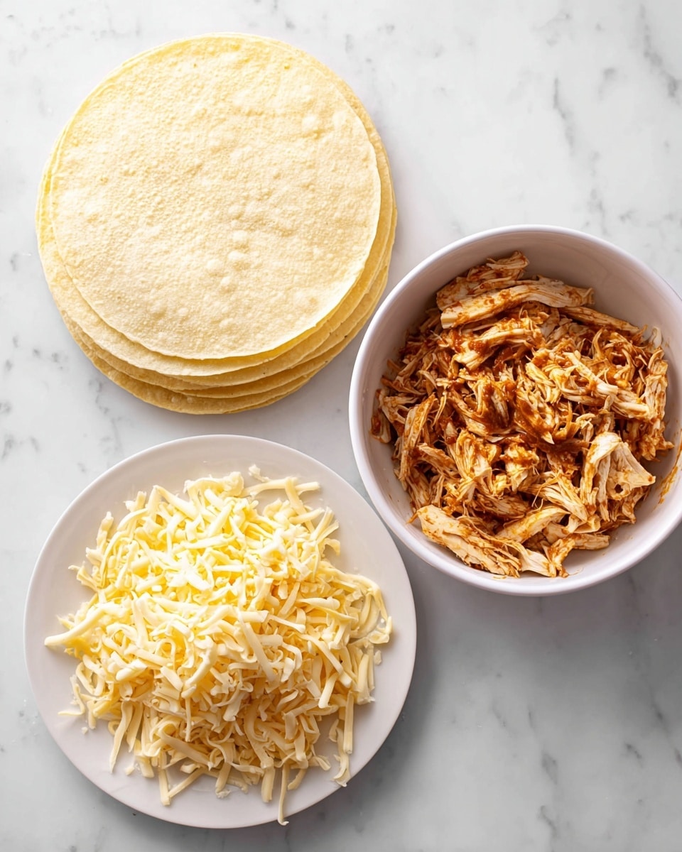 The image shows three white dishes on a white marbled surface. The top left dish has a stack of plain light yellow corn tortillas with a soft, smooth texture. On the right, a bowl is filled with shredded chicken mixed with a reddish-brown sauce, giving it a moist and slightly glossy look. At the bottom left, a plate holds a pile of shredded cheese in yellow and white colors, with a soft but firm texture. The arrangement forms a neat triangle of ingredients ready for making tacos or a similar dish. photo taken with an iphone --ar 4:5 --v 7