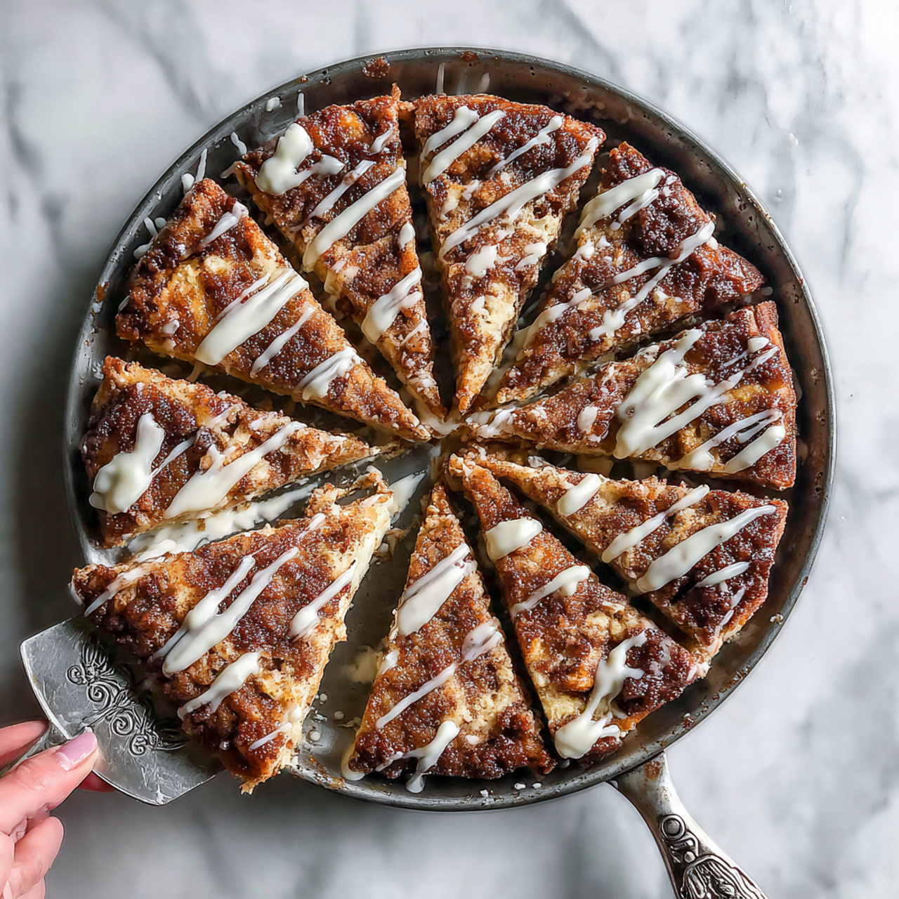 The image shows a round dessert with three main layers on a round white plate. The bottom layer is a golden-brown crust with a slightly puffed edge dusted with powdered sugar. The middle layer is a dark brown filling, likely chocolate or a rich cake, covered lightly with powdered sugar. The top layer is a light cream-colored icing or frosting applied in thick, parallel stripes across the surface. A metal pizza cutter is cutting a slice from the dessert, with the woman's hand holding it. The scene is set on a white marbled textured surface with a green pitcher and striped cloth in the background. Photo taken with an iphone --ar 4:5 --v 7