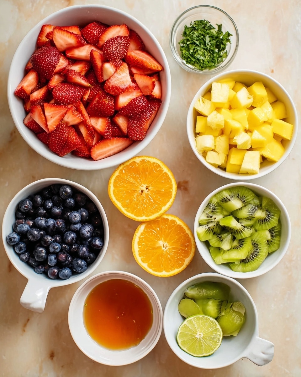 The image shows a white bowl filled with bright red, sliced strawberries in the top left corner. Around it are six small white bowls or ramekins containing different fruits and ingredients: diced yellow mango in the top right, chopped green herbs in a small ramekin above the mango, cubed pale yellow pineapple in a bowl with a handle on the left side, a bowl of dark blue blueberries at the bottom left, sliced green kiwi in a bowl on the right, and a small ramekin of orange honey or syrup near the bottom. In the center are two halves of a bright orange and two halves of a small lime, all placed on a white marbled surface. photo taken with an iphone --ar 4:5 --v 7