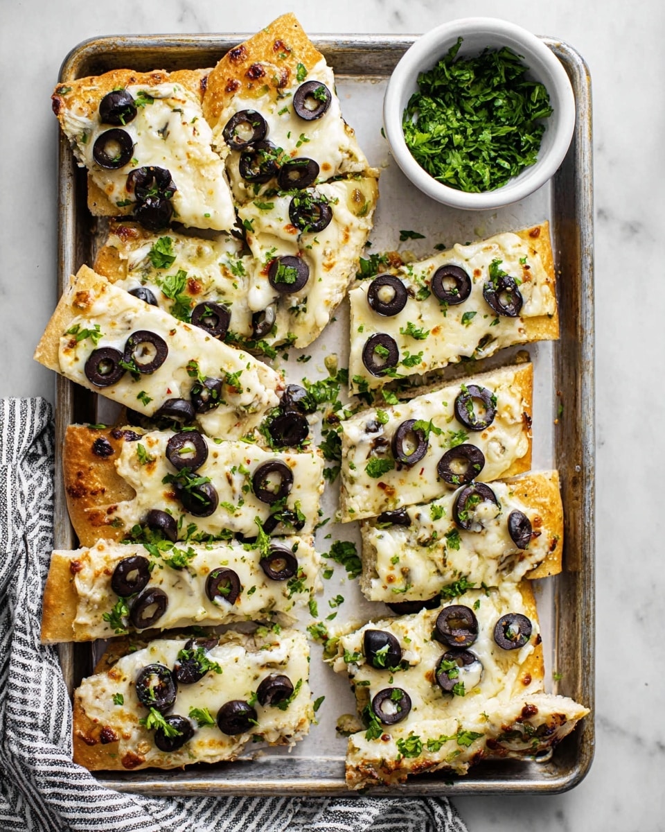 The image shows a tray with several slices of flatbread topped with a thick layer of melted white cheese. On top of the cheese are evenly spread black and green olive slices. The flatbread pieces have a golden-brown crust with some areas slightly toasted. Bright green chopped parsley is sprinkled over the flatbread, adding small pops of color. A small white bowl sits in the top right corner filled with more fresh green parsley. The tray rests on a white marbled surface, and a striped cloth is seen at the bottom left corner. photo taken with an iphone --ar 4:5 --v 7