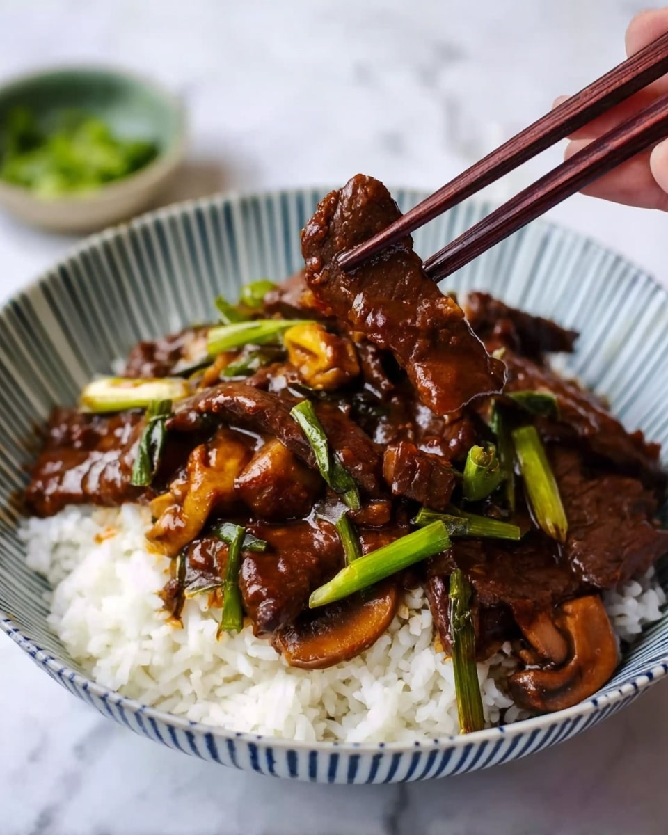 A white bowl with thin blue stripes around the edge holds a bed of white rice topped with dark brown beef slices in a glossy sauce. Mixed in with the beef are pieces of green onions and light brown mushroom slices, all coated with the same shiny sauce. A pair of dark wooden chopsticks, held by a woman's hand, lifts one piece of the beef above the bowl. The background shows a white marbled surface with a small bowl of green garnish slightly blurred. Photo taken with an iphone --ar 4:5 --v 7