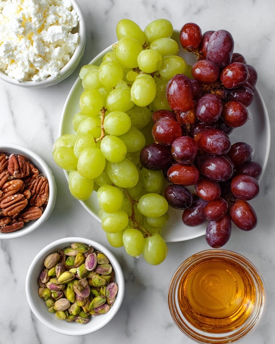 A white round plate in the center holds two bunches of grapes, one green and one red, with smooth, shiny skin and full, round shapes. Around the plate, four small white bowls are placed on a white marbled surface: the top left bowl contains soft white cottage cheese with a creamy texture, the top right bowl is filled with brown pecans showing their ridged surfaces, the bottom right bowl has green pistachios with some shells, and the bottom right corner has a small clear glass bowl filled with golden honey, its surface smooth and reflective, showing tiny bubbles inside. Photo taken with an iphone --ar 4:5 --v 7