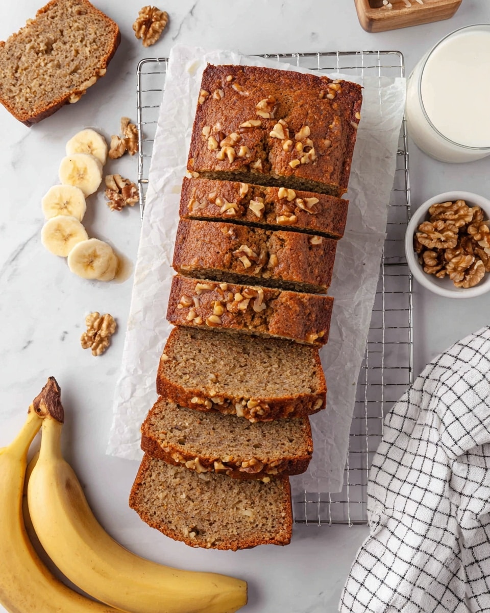 A loaf of banana nut bread with five visible slices stacked vertically on a white marbled surface, each slice showing a dense, moist texture with small walnut pieces inside. The top layer is covered with chopped walnuts, which are golden brown and slightly crunchy. A woman's hand is lifting the top slice, showing the cake's soft and textured inside, light brown with specks of banana and nuts. The background is softly blurred, with white kitchen jars and a white cloth. Photo taken with an iphone --ar 4:5 --v 7