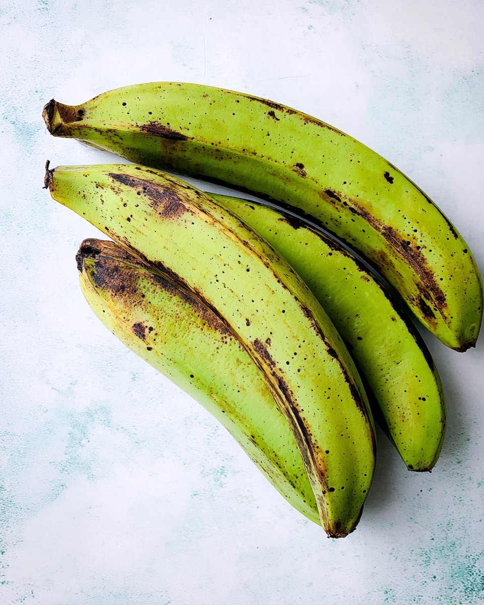 Three green plantains with brown spots lie on a white marbled surface. They are placed close to each other, all showing their curved shapes with visible dark ridges and speckles. The plantains have smooth textures with slightly rough ends, and the lighting highlights their fresh green color with natural imperfections. photo taken with an iphone --ar 4:5 --v 7