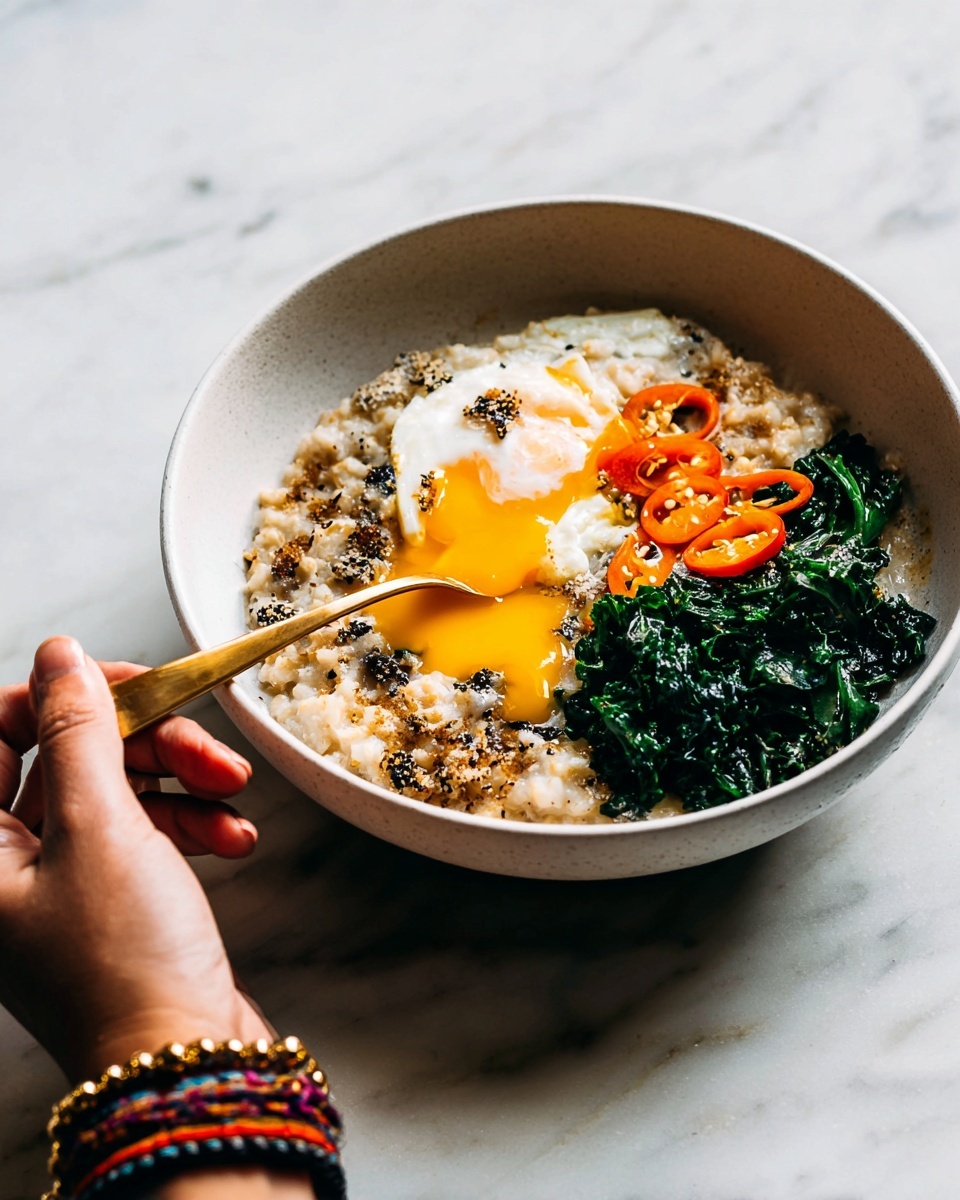 Savory Miso Oatmeal with Jammy Egg Recipe 5 A white bowl holds a three-part meal, starting with creamy oatmeal speckled with black and browned bits on the left side. In the middle, there is a soft poached egg with a bright yellow runny yolk flowing over the oatmeal. On the right side, dark green cooked kale is topped with bright orange slices of chili pepper. A gold spoon rests in the oatmeal, held by a woman's hand wearing a colorful woven bracelet. The bowl sits on a white marbled surface. photo taken with an iphone --ar 4:5 --v 7