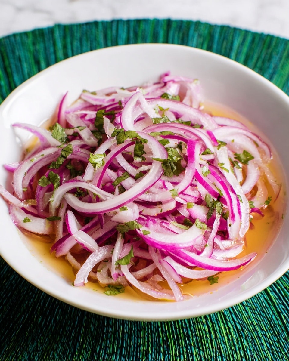 A white bowl filled with thinly sliced red onions forming the main layer, mixed with small green cilantro leaves scattered evenly on top, all sitting in a light, slightly orange-colored liquid that covers the bottom of the bowl. The onions have a fresh, crisp texture with a mix of light purple and white colors. The bowl is placed on a white marbled surface with a green woven mat underneath. Photo taken with an iphone --ar 4:5 --v 7