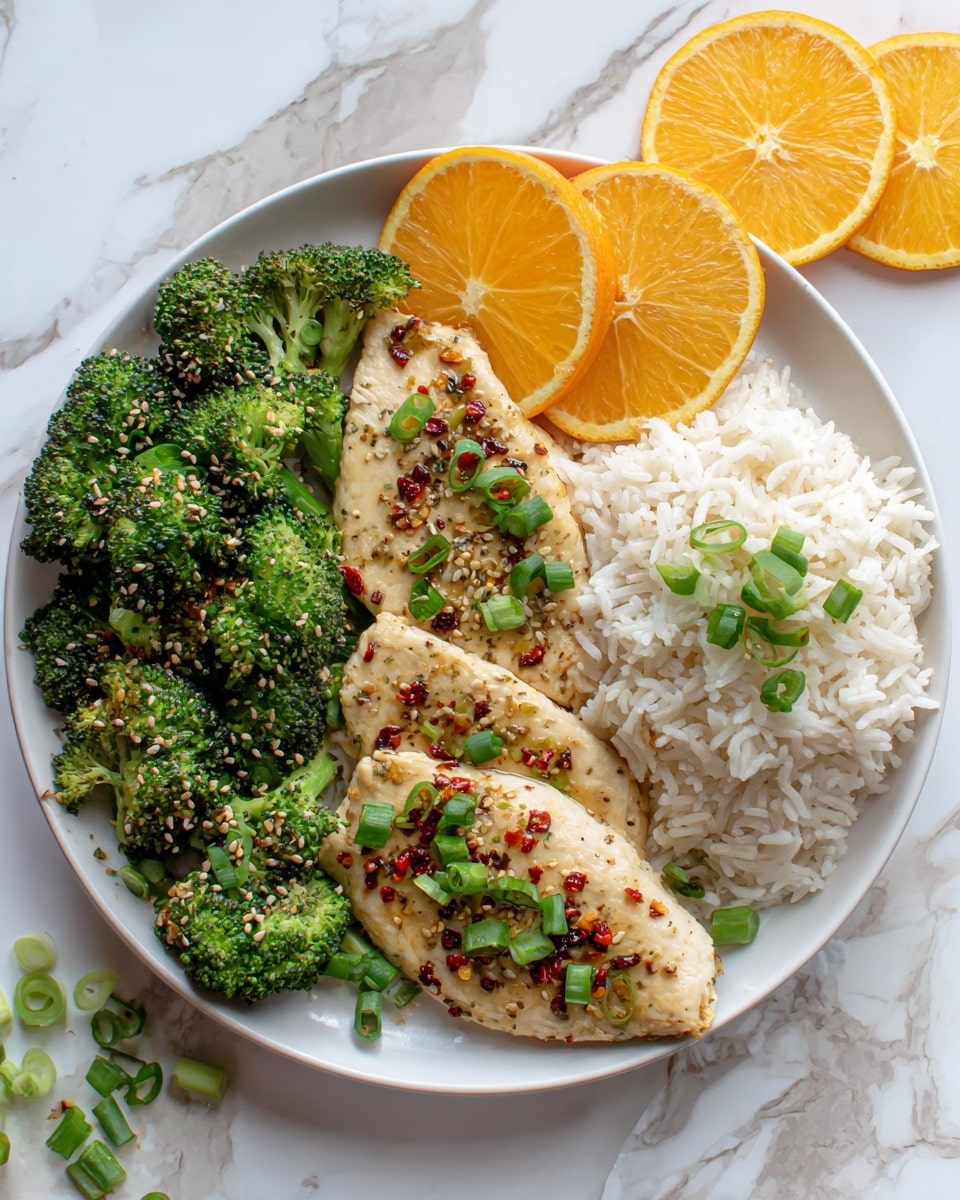 A white plate holds a neat meal with three main parts: on the left side, bright green roasted broccoli with some light brown char marks and sesame seeds on top; in the middle, two pieces of light golden chicken fillets covered with small bits of red chili flakes, sesame seeds, and chopped green onions scattered over; on the right side, a fluffy light beige bed of white rice topped with a few chopped green onions, next to two thin orange slices placed at the edge of the rice. The plate sits on a white marbled surface with some orange slices and green onions around. photo taken with an iphone --ar 4:5 --v 7