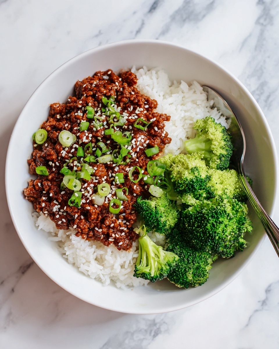 In a white bowl, there are three layers: at the bottom is a layer of white rice, on top of the rice is a layer of brown minced meat sauce with a slightly rough texture, sprinkled evenly with white sesame seeds and chopped green onions, and next to the meat is a layer of bright green steamed broccoli florets with a soft texture. The bowl is placed on a white marbled surface, and there is a silver spoon partly visible on the right side of the bowl. photo taken with an iphone --ar 4:5 --v 7
