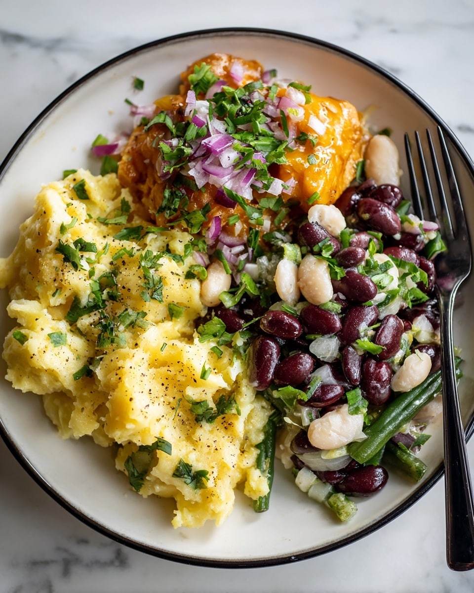 The image shows a close-up of a white plate with a black rim on a white marbled surface, featuring three main parts. On the left side, there is a creamy yellow potato salad with visible small green herbs mixed in, and specks of black pepper on top. Next to it, in the middle and right sections, there is a colorful bean salad made of dark red kidney beans, white beans, and cut green beans mixed with small pieces of purple onions and sprinkled with chopped green herbs. At the top left corner of the plate, part of a piece of cooked chicken covered with a shiny orange sauce and topped with small diced red onions and freshly chopped green herbs is visible. A black fork rests on the right side of the plate. photo taken with an iphone --ar 4:5 --v 7