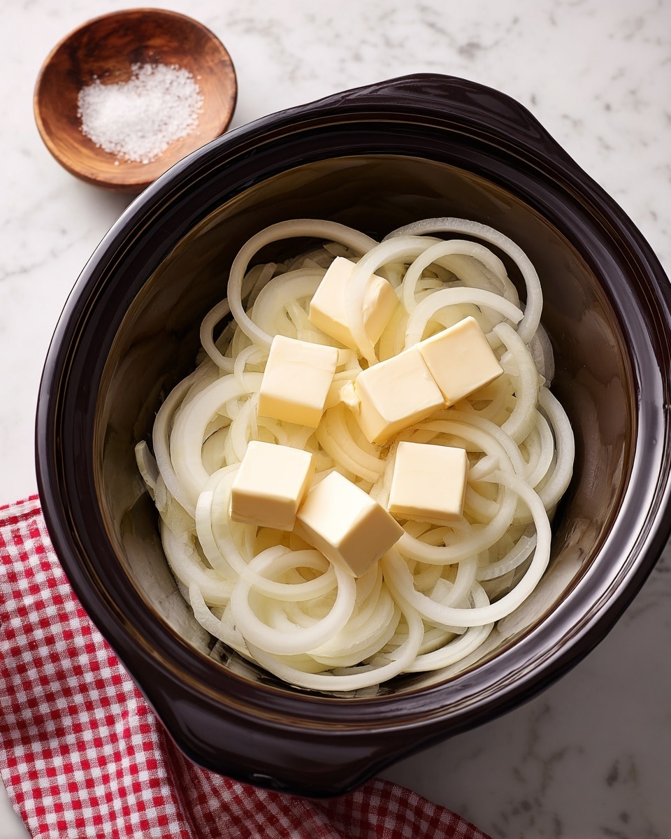 Inside a black slow cooker, there are many thin, white onion rings stacked as the first layer, creating a tangled and soft texture. On top of the onion rings, small square pieces of pale yellow butter are spread evenly, showing a smooth and creamy texture. The slow cooker sits on a white marbled surface. Near the cooker, there is a small wooden bowl with salt and a red and white checkered cloth peeking in from the side. The overall look is clean and simple, with soft colors and clear details. photo taken with an iphone --ar 4:5 --v 7