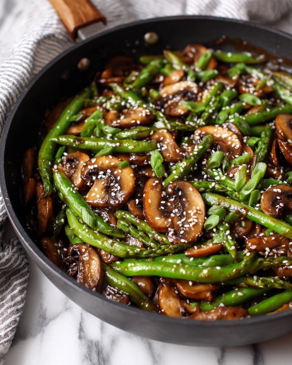 A close-up view of a black pan filled with a stir-fry dish showing three main layers: the bottom layer contains shiny brown sauce coating the other ingredients; the middle layer features white, tender sliced mushrooms scattered throughout; the top layer includes bright green sugar snap peas and chopped green onions evenly mixed, topped with small white sesame seeds. The pan rests on a white marbled surface with a grey and white striped cloth partially visible in the background. photo taken with an iphone --ar 4:5 --v 7
