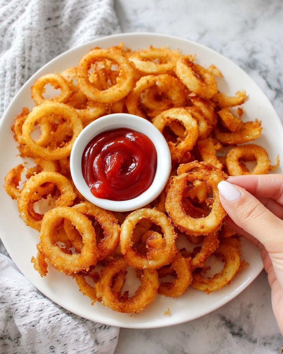 A white plate filled with golden brown curly fries arranged all around a small white cup filled with bright red ketchup in the center. A woman's hand holds one curly fry dipped slightly into the ketchup, showing the crispy texture and light seasoning on the fry. The background is a white marbled texture. photo taken with an iphone --ar 4:5 --v 7