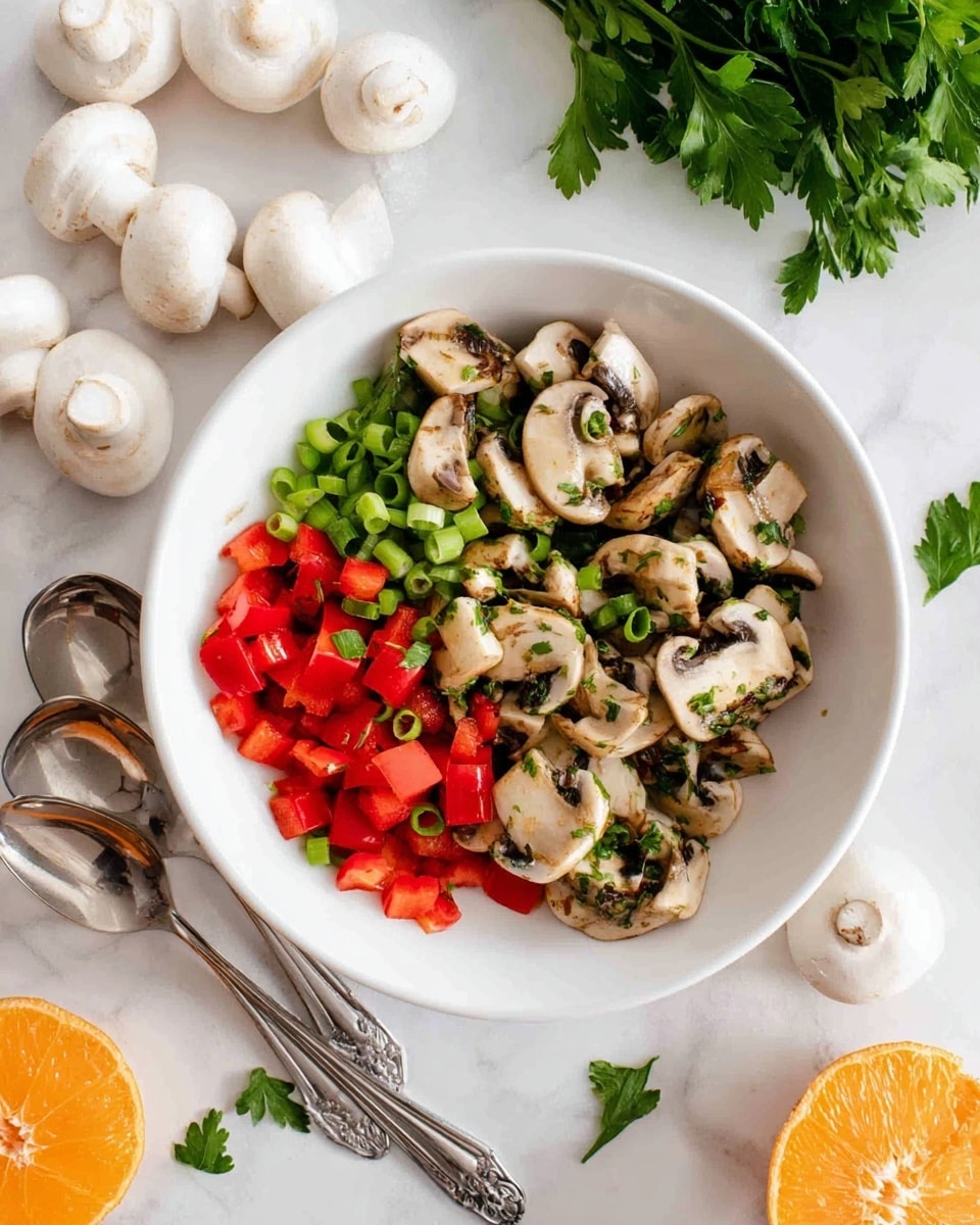 A white bowl filled with a fresh mushroom salad. The salad has three main layers: the bottom layer with chopped red bell peppers in bright red cubes, the middle layer with sliced green onions in small green and white pieces, and the top layer with halved white mushrooms showing both their pale tops and dark gills. Small bits of green parsley are sprinkled all over the salad, adding a touch of texture. The bowl is placed on a white marbled surface, surrounded by whole white mushrooms, a bunch of green parsley leaves near the top, a half orange on the right, and two silver spoons laying next to the bowl on the left. The setting looks clean and fresh with natural light. Photo taken with an iphone --ar 4:5 --v 7
