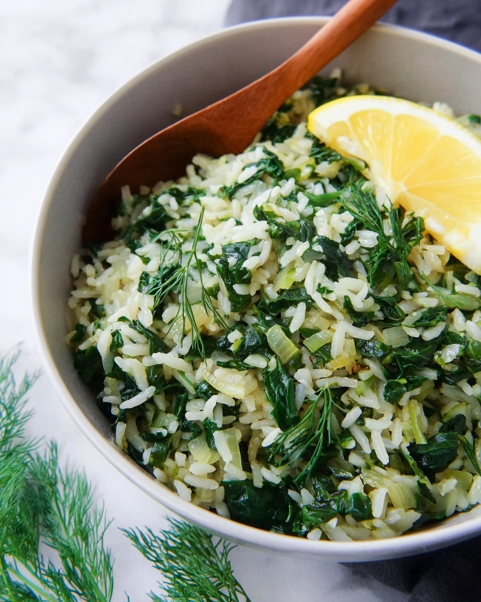 A close-up view of a bowl filled with cooked rice mixed with wilted green leafy vegetables and small pieces of translucent onion, creating a textured green and white mixture. On the right side of the dish, there is a thin wedge of yellow lemon resting on top of the rice. A wooden spoon is partially visible, sticking out of the bowl, suggesting the dish is ready to be served. The bowl is white and sits on a white marbled surface with some fresh green dill sprigs around the base. Photo taken with an iphone --ar 4:5 --v 7