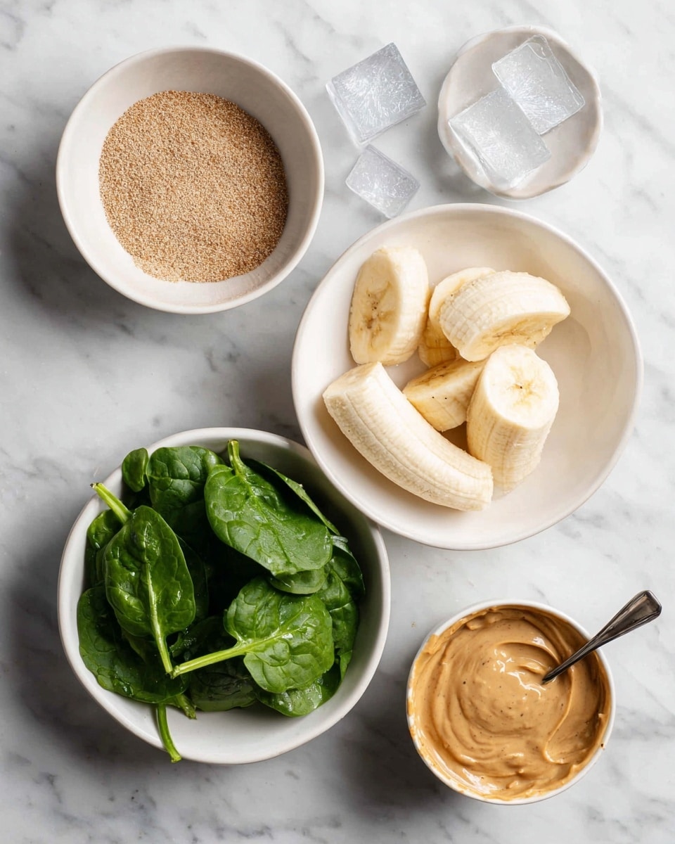 The image shows five separate white bowls arranged on a white marbled surface. The top center bowl contains a light brown, finely ground powder. To the right, a bowl holds several clear ice cubes. Below, a bowl filled with peeled bananas, light yellow with some brown specks, is placed. To the bottom left, another bowl contains fresh, dark green spinach leaves with a slightly glossy texture. The last bowl, located to the bottom right, has a creamy, light brown peanut butter-like substance with a spoon resting inside. The photo taken with an iphone --ar 4:5 --v 7