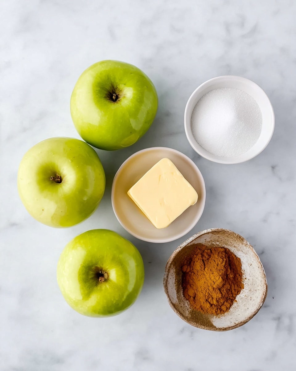 The image shows three green apples with smooth skin arranged close together on a white marbled surface. To the upper right, there is a small white bowl filled with white granulated sugar. Below the sugar, a small white bowl holds a square piece of pale yellow butter. At the bottom center of the image, there is a small rustic bowl filled with bright orange-brown ground cinnamon. The items are spaced evenly on the white marbled surface with soft natural light creating subtle shadows. photo taken with an iphone --ar 4:5 --v 7
