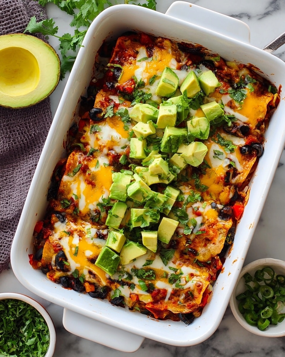 A white rectangular baking dish holds a baked layered dish with six visible portions. The bottom layer is a mix of cooked vegetables, including black olives and red peppers, topped with melted yellow and white cheese that has browned slightly in spots. On top of the cheese is a generous layer of fresh green avocado chunks scattered mostly in the center, along with a few small green onion slices and cilantro leaves for garnish. The dish sits on a white marbled surface with an avocado half and a small bowl of chopped herbs nearby. Photo taken with an iphone --ar 4:5 --v 7