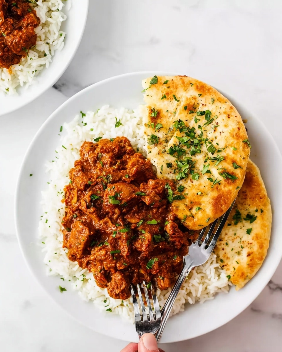 The image shows a white plate filled with three layers. The bottom layer is soft, fluffy white rice, spread evenly over the plate. On top of the rice sits a thick layer of reddish-brown curry with visible chunks of meat and small bits of herbs sprinkled on it. To the right side of the rice and curry sits a layer of golden-brown flatbread topped with chopped green herbs. There is a silver fork placed beside the plate on a white marbled surface. A woman's hand is holding the flatbread, slightly lifting it. The photo taken with an iphone --ar 4:5 --v 7