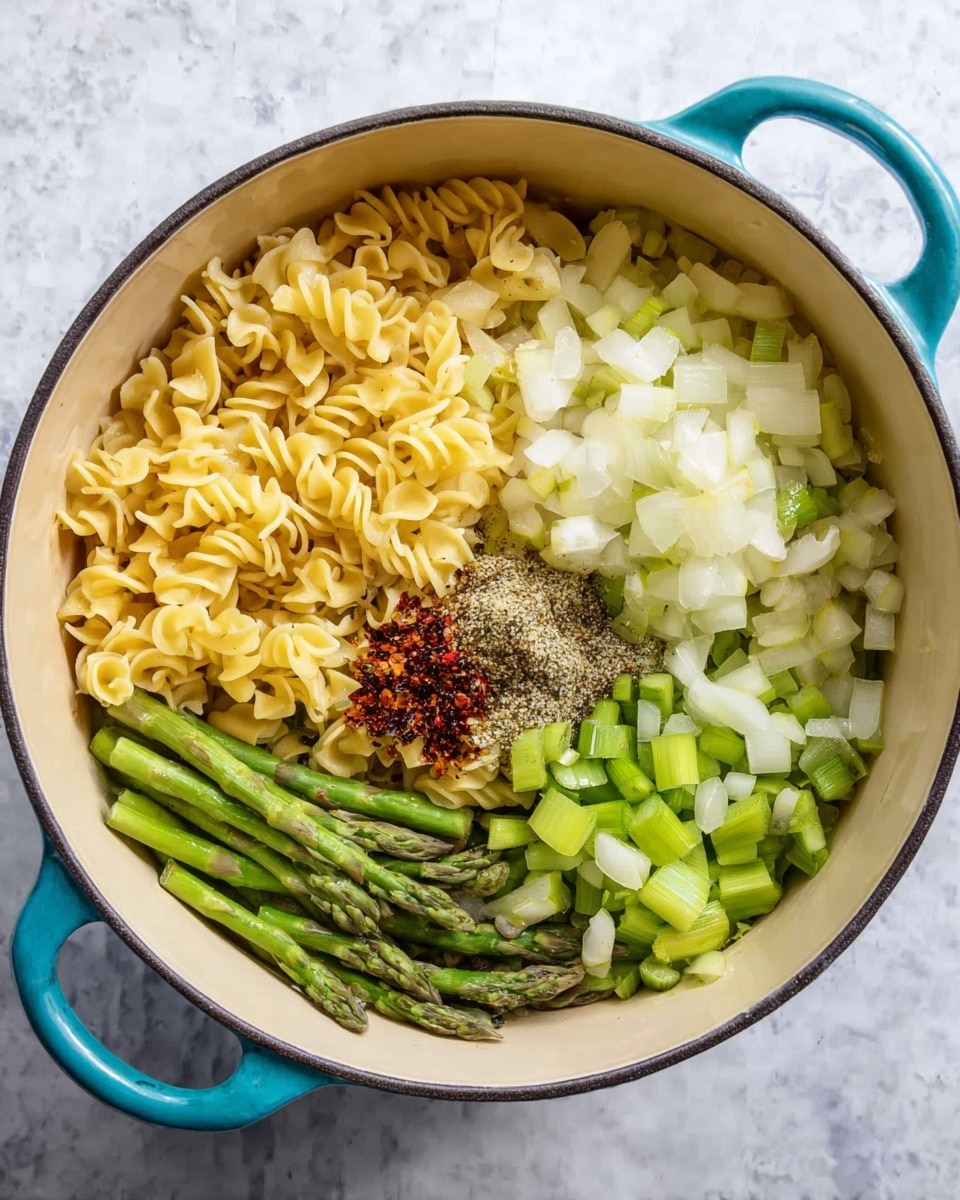 Inside a white pot with turquoise handles, the dish shows four main layers arranged separately. On the left side, there is a layer of light yellow curly pasta with ruffled edges. To the right, there is a layer of chopped white onions with smooth, round pieces. Next to the onions, small pieces of light green celery are placed. In the bottom right area, there are bright green asparagus spears and stalk pieces, some sliced and some whole. In the center, a small pile of spices including coarse black pepper and red chili flakes is visible on top of the onions and pasta. The pot rests on a white marbled surface. photo taken with an iphone --ar 4:5 --v 7