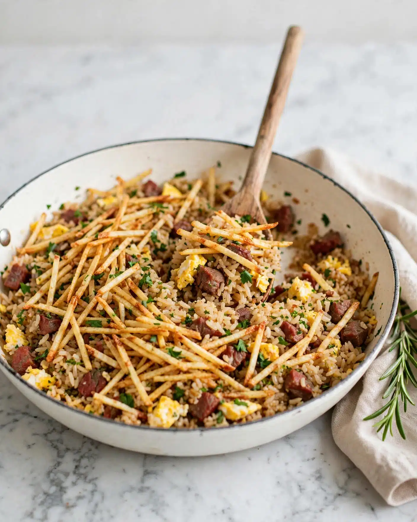 Arroz Biro-Biro (Brazilian Fried Rice) Recipe 5 A large white pan filled with fried rice mixed with thin, crispy golden-brown strips that look like fried potatoes on top. The rice is white with scattered bits of yellow scrambled eggs and small pieces of cooked meat that have reddish-brown hues. There are also small green herbs mixed in, adding a touch of color. A spoon with a wooden handle scoops up some rice from the center, showing the texture and mix of ingredients. The pan is set on a white marbled surface. Photo taken with an iphone --ar 4:5 --v 7