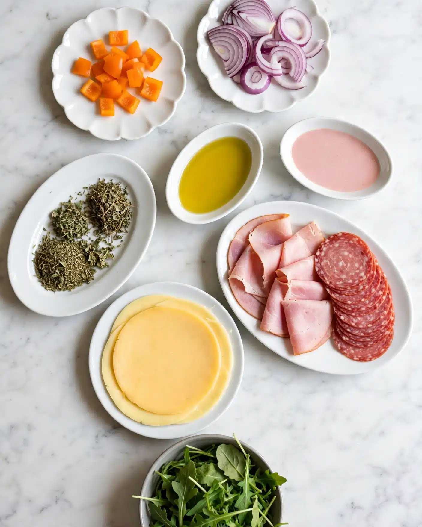 Easy Keto Salami and Italian Dressing Wraps Recipe 4 The image shows several small white plates and bowls arranged on a white marbled surface, each holding different ingredients: one small scalloped white plate has small orange pieces, another scalloped white plate holds sliced purple onions, an oval white plate has dried green herbs, a small oval white bowl contains yellow olive oil, and another small oval white bowl has a light pink liquid. A larger white oval plate contains thin slices of pink ham and a stack of round reddish-pink salami slices. Below is a round white plate with a single layer of smooth, yellow cheese. A small round gray bowl at the bottom is filled with fresh green arugula leaves. Photo taken with an iphone --ar 4:5 --v 7